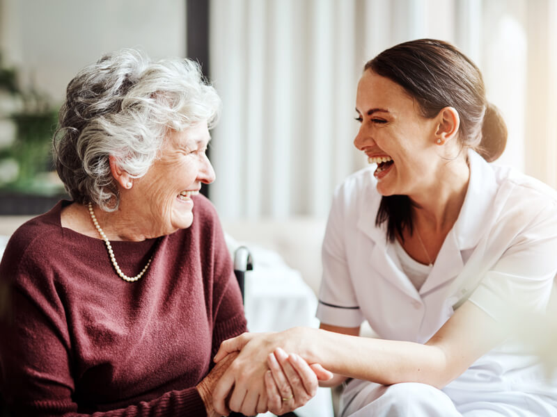 in-home care nurse and woman laughing